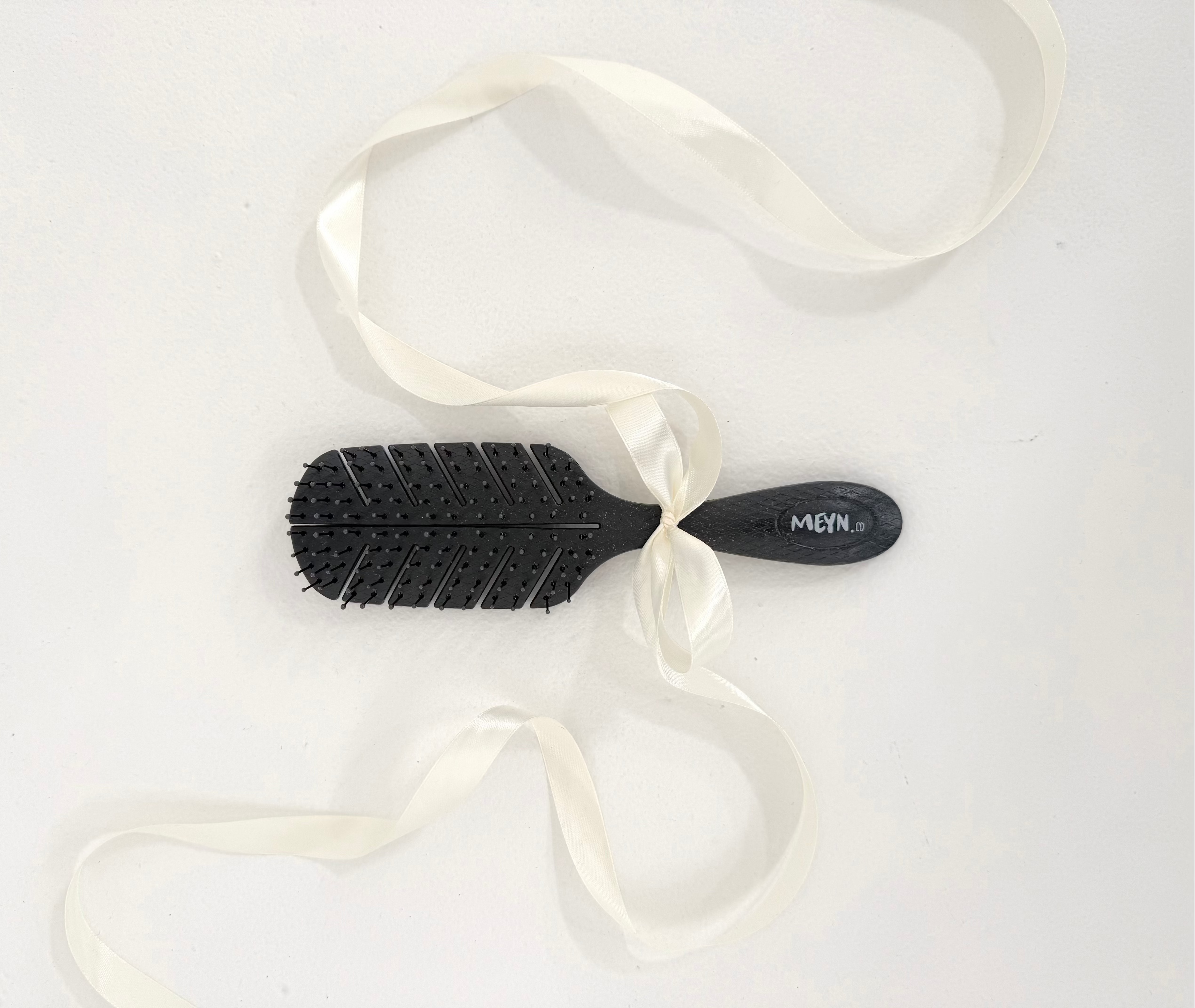 Meyn.co The Signature Brush with flexible black bristles and curved handle